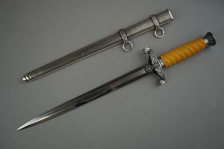 A picture containing weapon, wall, indoor, sword

Description automatically generated