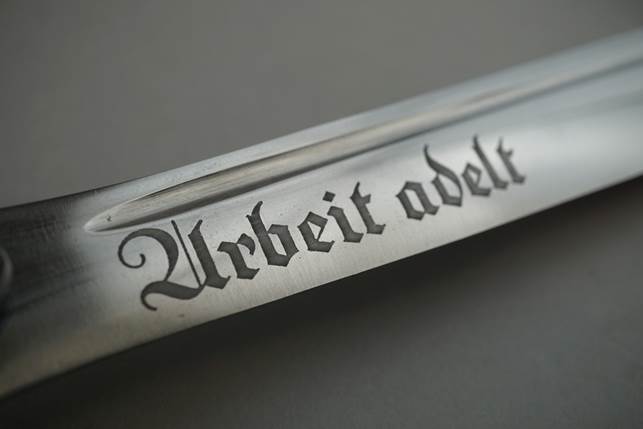 Close-up of a sword with text on it

Description automatically generated with low confidence