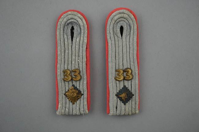 A pair of shoulder straps with numbers

Description automatically generated