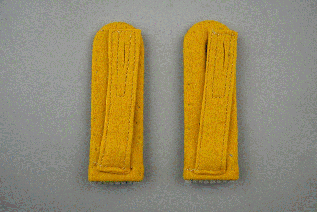 A pair of yellow felt straps

Description automatically generated