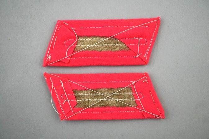 A pair of red fabric patches

Description automatically generated