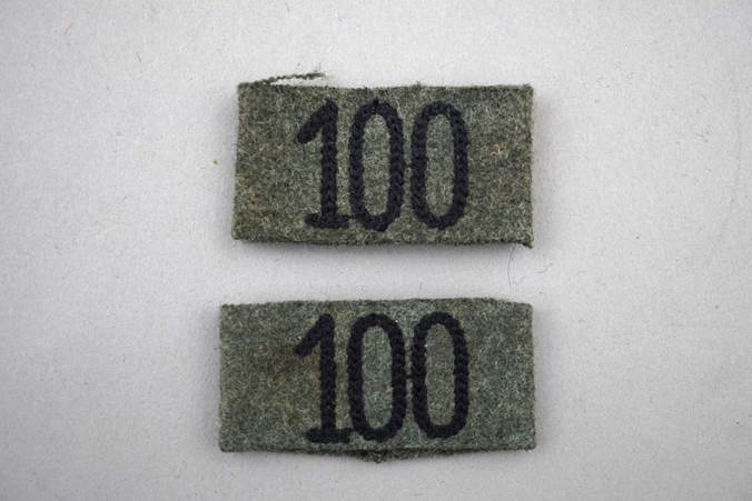 A pair of green fabric labels with black numbers

Description automatically generated