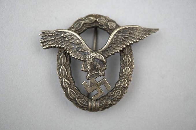 A metal eagle with a swastika in the middle

Description automatically generated