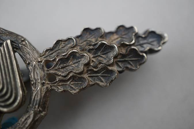 Close-up of a metal object with leaves

Description automatically generated