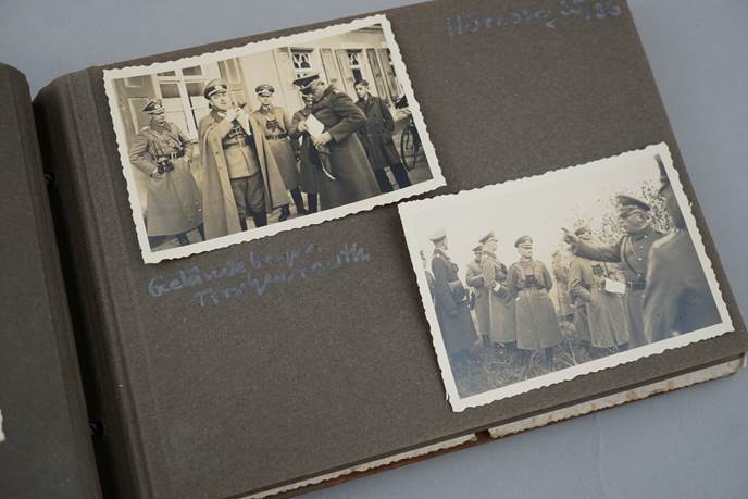 A photo album with pictures of soldiers

Description automatically generated