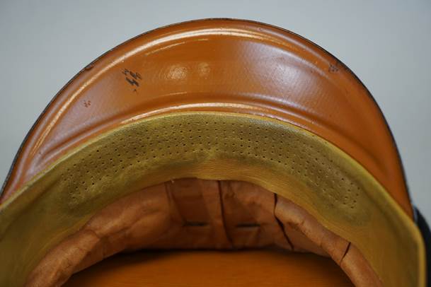 A brown leather helmet with a yellow cushion

Description automatically generated with medium confidence