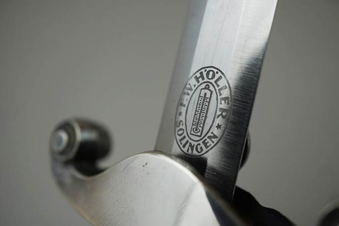 Close-up of a sword with a logo

Description automatically generated
