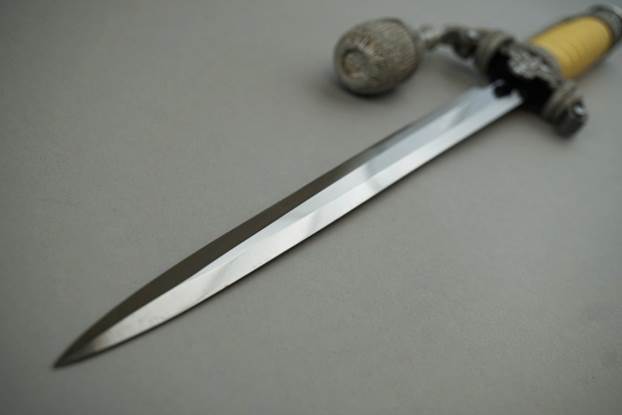 A long sharp knife with a bead

Description automatically generated