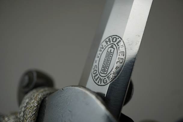 Close-up of a knife with a logo on it

Description automatically generated