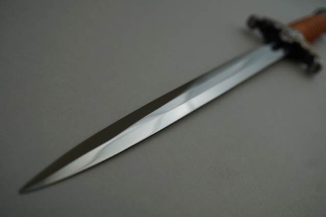 A long silver sword with a black handle

Description automatically generated
