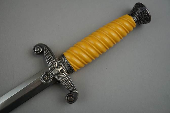 A yellow and silver knife with a handle

Description automatically generated