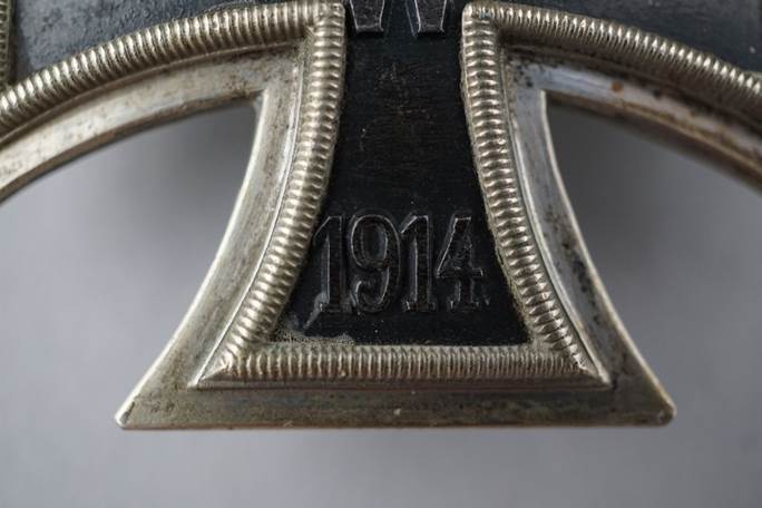 Close-up of a cross with numbers and letters

Description automatically generated