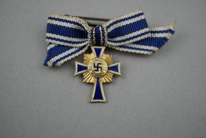 A gold cross with blue and white ribbon

Description automatically generated