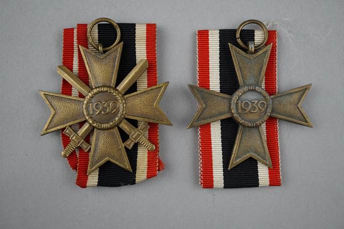 A pair of medals with ribbons

Description automatically generated