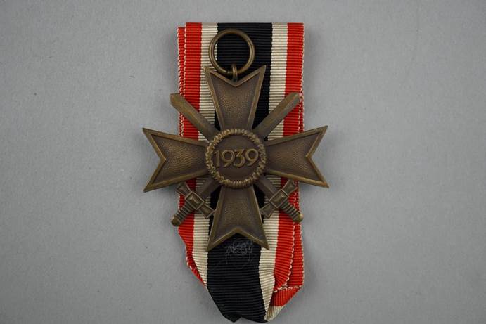 A medal with a number and cross on it

Description automatically generated