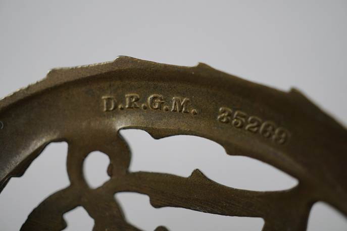 Close-up of a metal object with engraved text

Description automatically generated