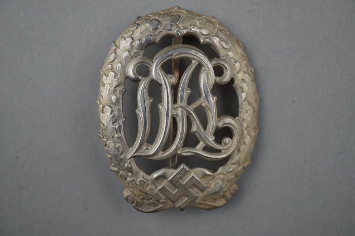 A silver metal object with a letter

Description automatically generated with medium confidence