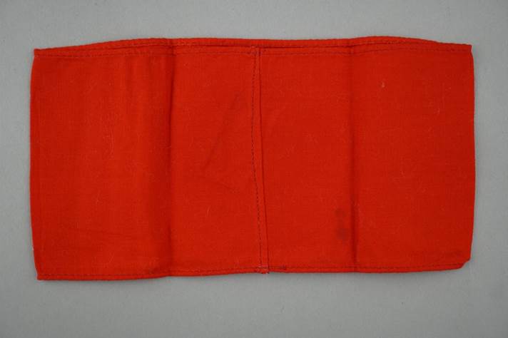A red cloth folded on a gray surface

Description automatically generated