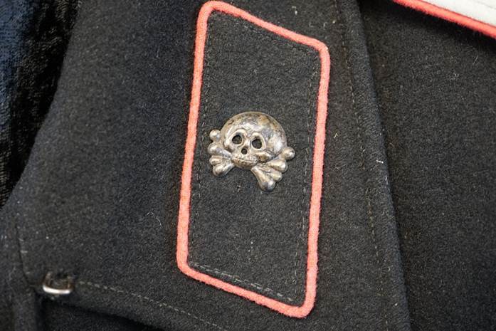 A close-up of a skull and crossbones patch

Description automatically generated