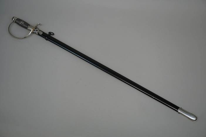 A long black sword with a handle

Description automatically generated