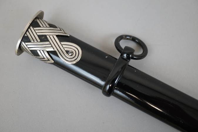 A black and silver sword holder

Description automatically generated