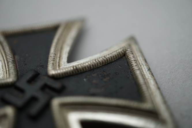 Close-up of a black and silver cross

Description automatically generated