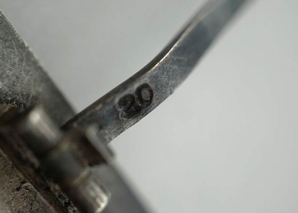Close-up of a metal handle with a number

Description automatically generated