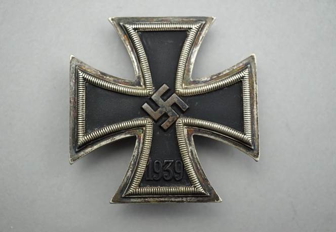 A black and silver cross with a symbol

Description automatically generated