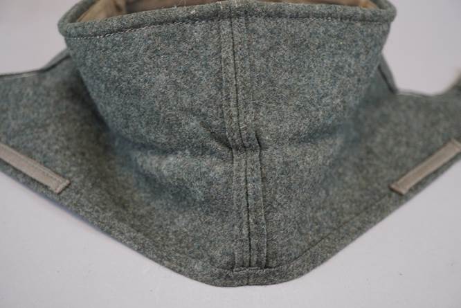 A grey fleece scarf on a white surface

Description automatically generated