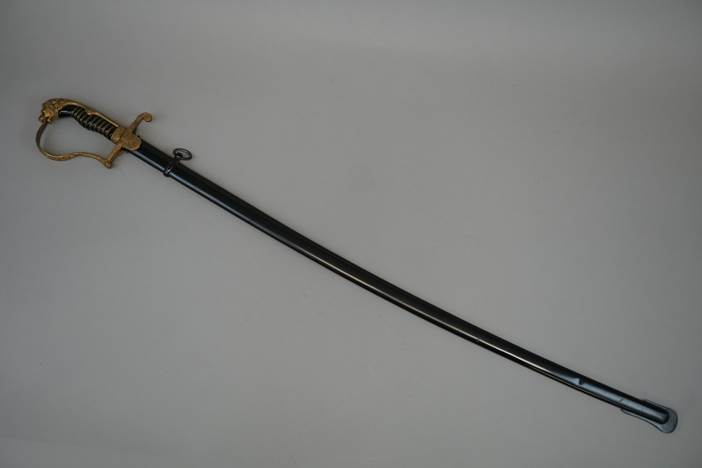 A sword with a gold handle

Description automatically generated