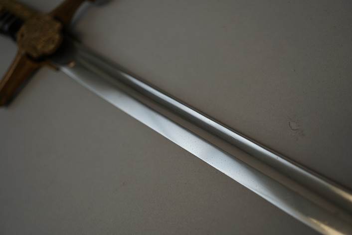 Close-up of a sword

Description automatically generated