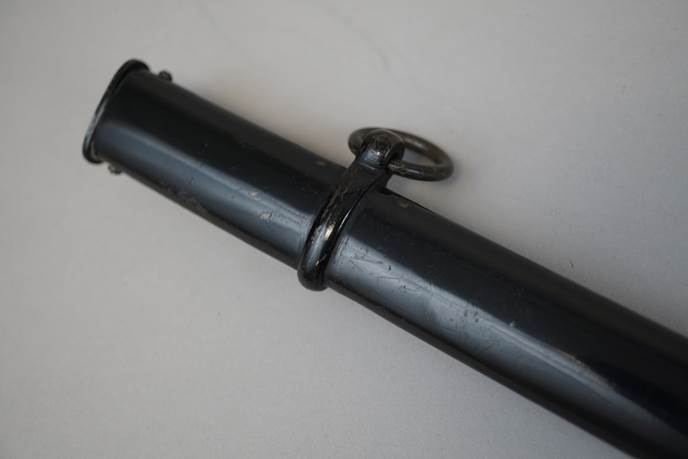 A black pipe with a ring attached

Description automatically generated