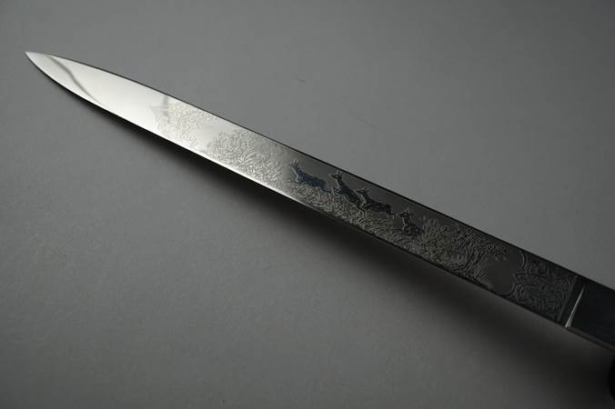 A knife with a design on it

Description automatically generated