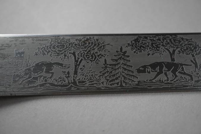 A metal object with a picture of a wolf and trees

Description automatically generated