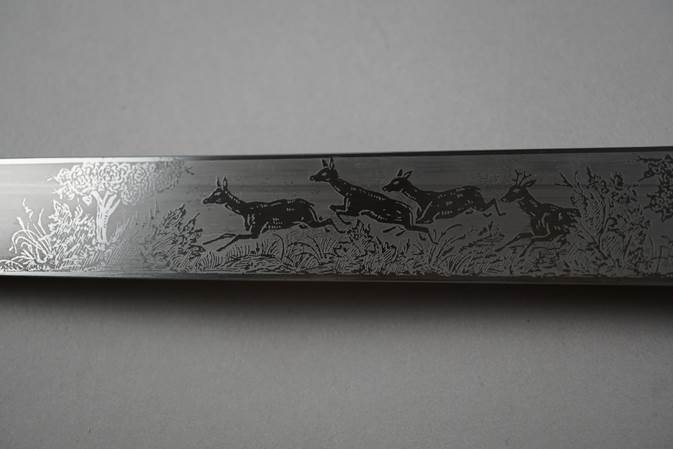 A knife with a picture of deer

Description automatically generated