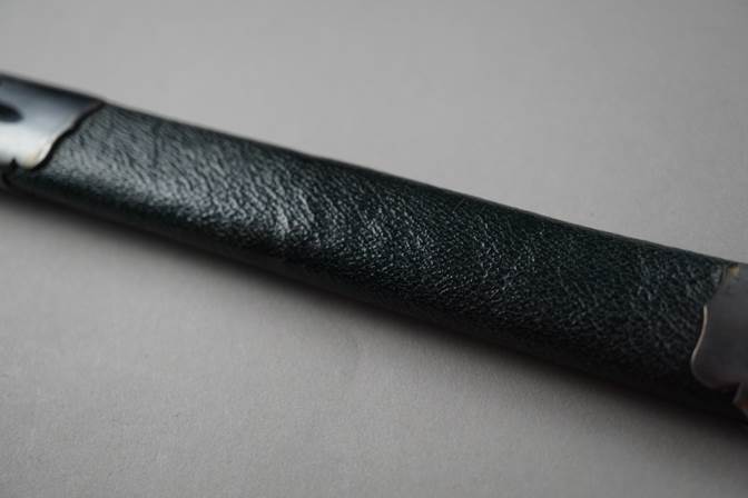 A black leather pencil case

Description automatically generated