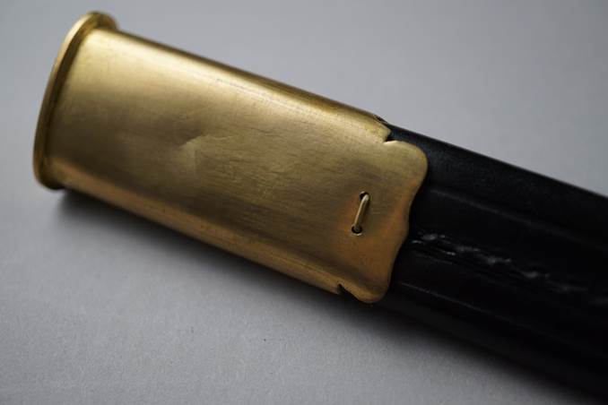A close-up of a gold and black handle

Description automatically generated