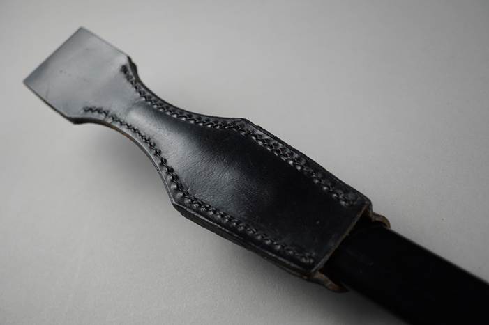 A black leather sheath on a black handle

Description automatically generated