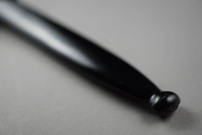 Close-up of a black pen

Description automatically generated
