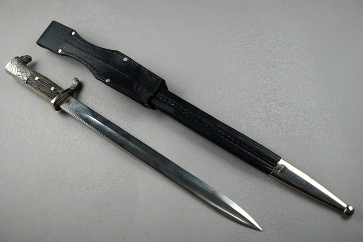 A knife and sheath on a grey surface

Description automatically generated