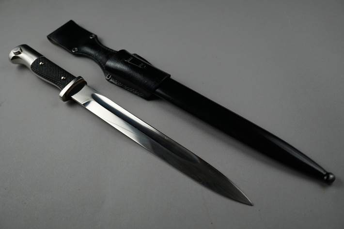 A knife and sheath on a white surface

Description automatically generated