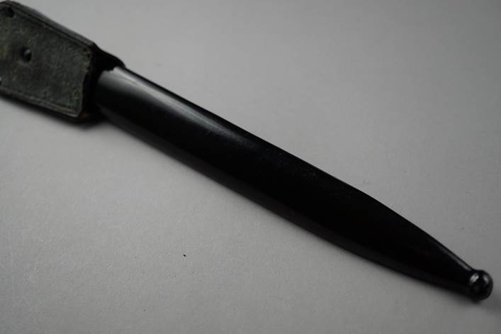 A black knife with a black handle

Description automatically generated