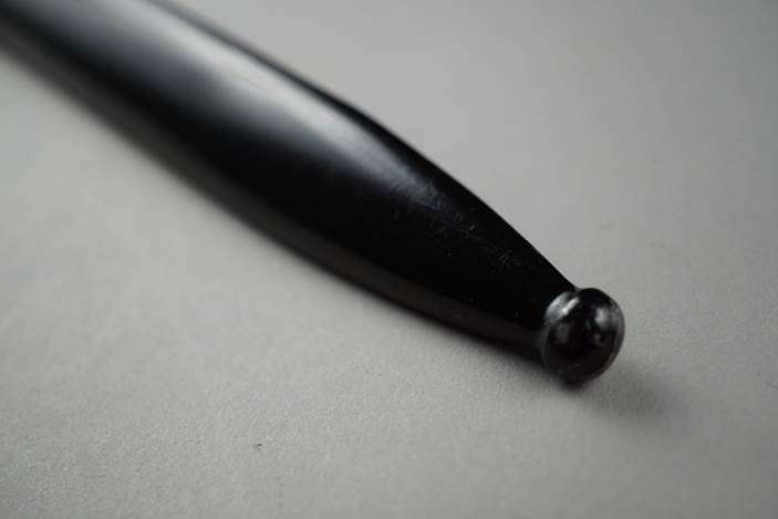 A close-up of a black pen

Description automatically generated