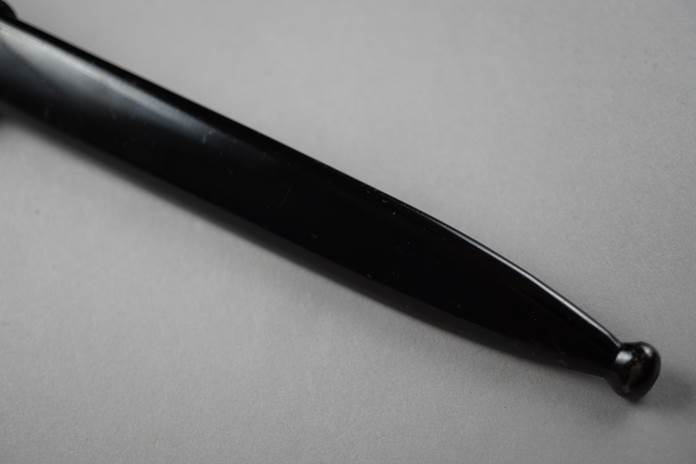 A black pen on a white surface

Description automatically generated
