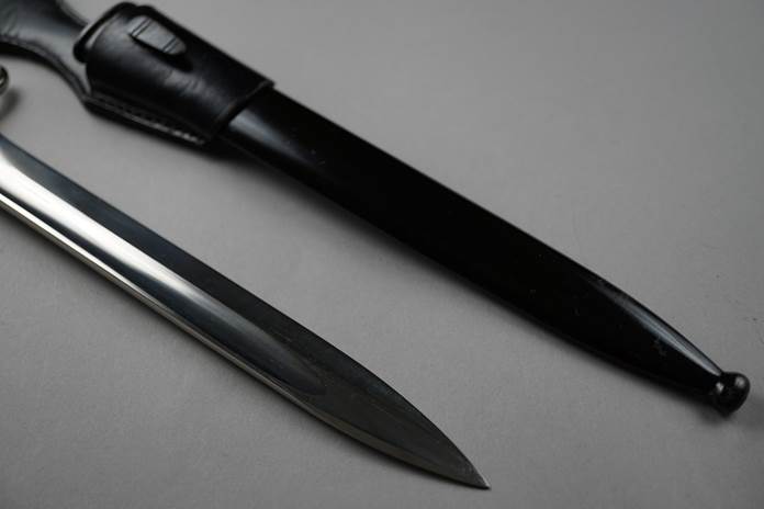 A knife and sheath on a white surface

Description automatically generated