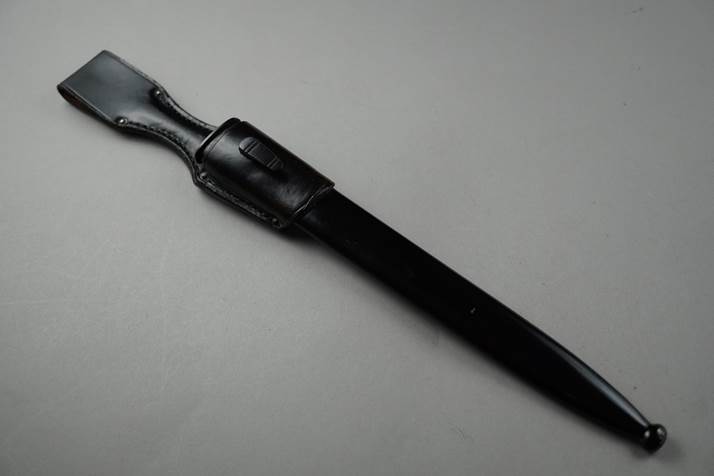 A black knife with a black sheath

Description automatically generated