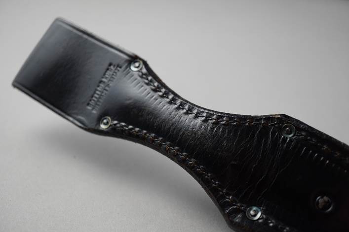 A close-up of a black leather tool

Description automatically generated