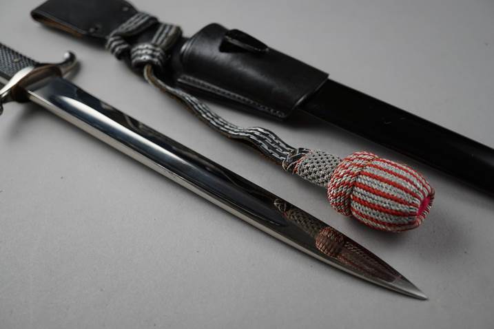 A knife and sheath with a string

Description automatically generated