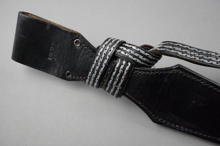 A black leather belt with a white stripe

Description automatically generated