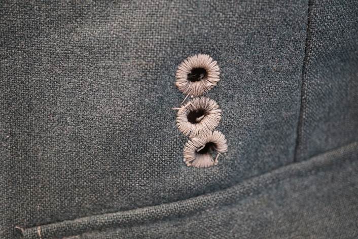 A close-up of a buttonhole

Description automatically generated